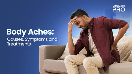 Indian man on sofa holding head and lower back in pain — Body Aches Causes, Symptoms and Treatments | UltraCare PRO