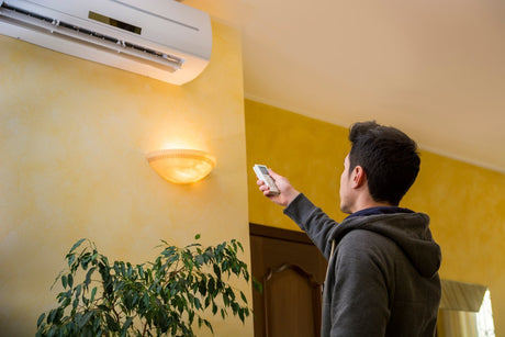 Man-Operating-Air-Conditioner-With-Remote